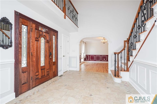 foyer entrance featuring an inviting chandelier and a high ceiling