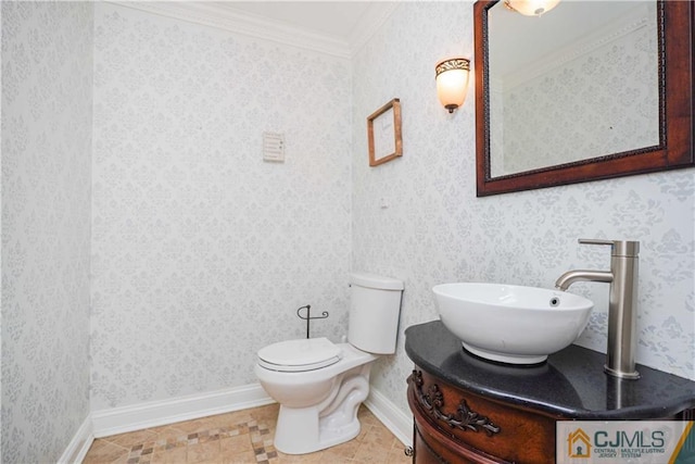 bathroom with wallpapered walls, baseboards, toilet, ornamental molding, and vanity