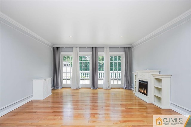 unfurnished living room with baseboards, light wood-style flooring, a lit fireplace, crown molding, and recessed lighting