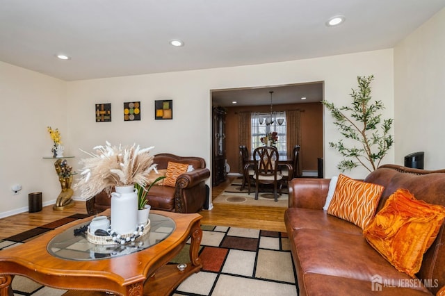 living room featuring a notable chandelier, wood finished floors, and recessed lighting