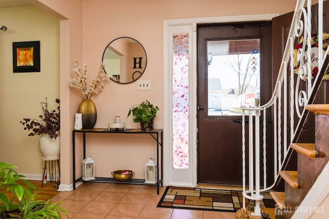 entryway featuring a wealth of natural light, tile patterned flooring, and stairs