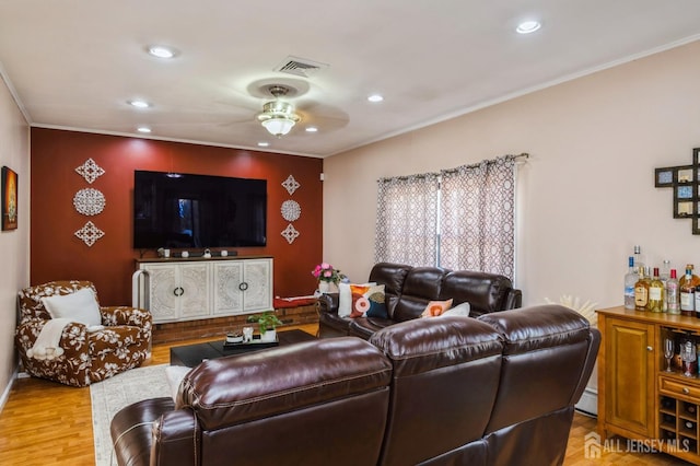 living area featuring ornamental molding, wood finished floors, visible vents, and recessed lighting