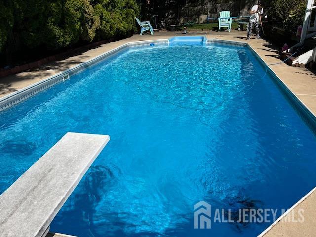 pool featuring a patio and a diving board