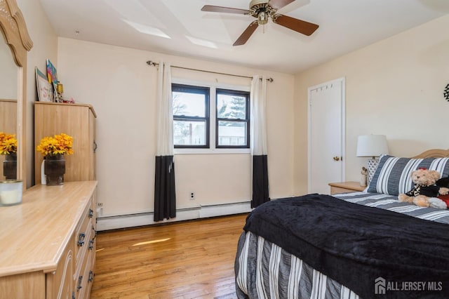 bedroom with a baseboard radiator, light wood-style floors, and a ceiling fan