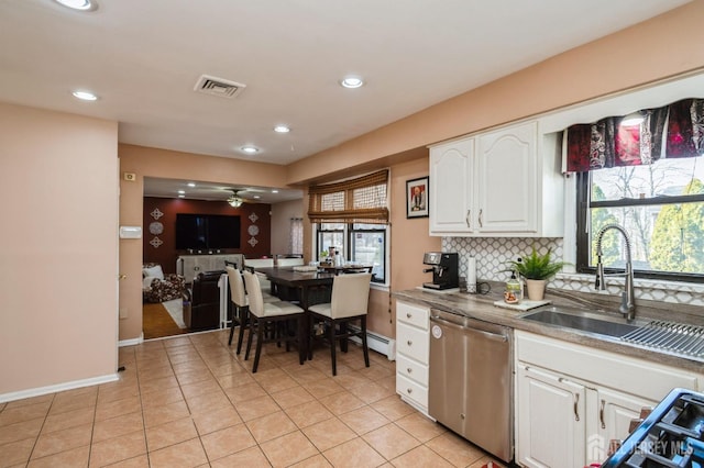 kitchen with decorative backsplash, dishwasher, ceiling fan, white cabinetry, and a sink