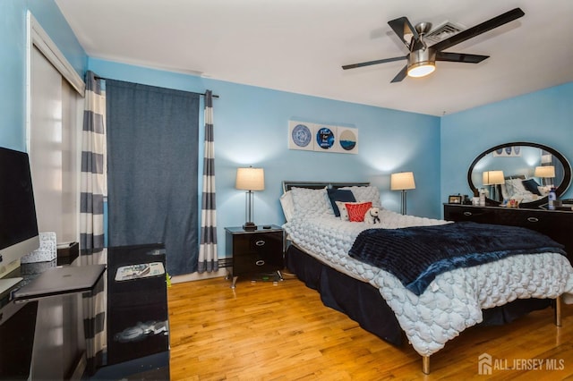 bedroom with ceiling fan, light wood finished floors, and visible vents