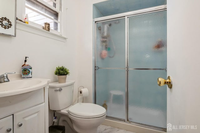 bathroom featuring marble finish floor, toilet, a shower stall, and vanity