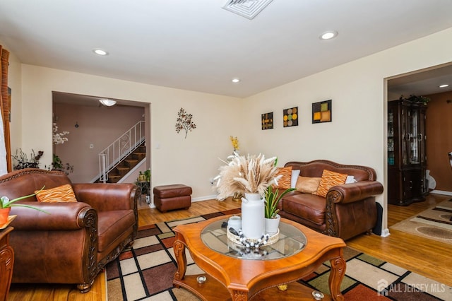 living area featuring recessed lighting, visible vents, stairway, and wood finished floors