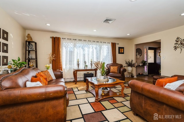 living area featuring a baseboard radiator, visible vents, light wood-style flooring, and recessed lighting