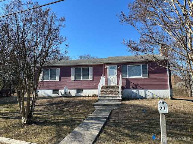 view of front of house featuring a chimney and a front lawn