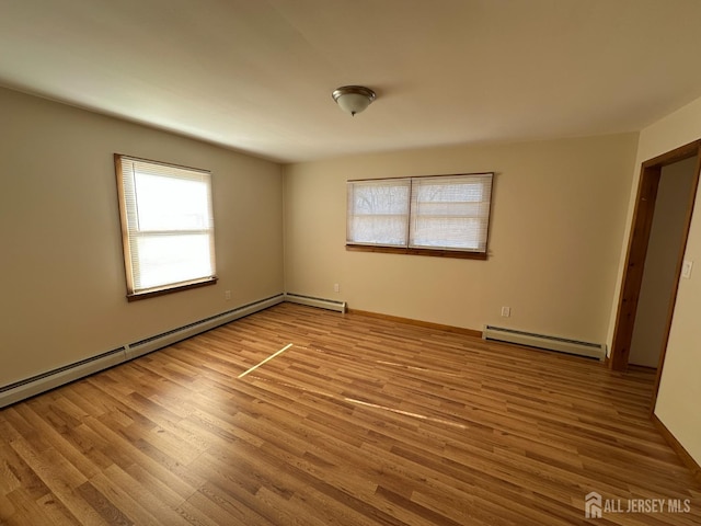 empty room with wood finished floors and a baseboard radiator