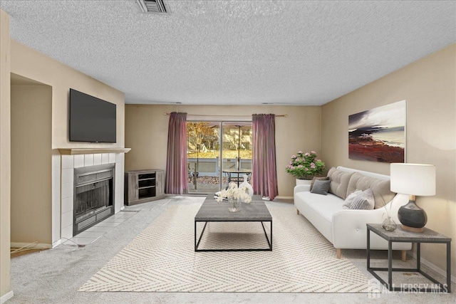 carpeted living room with a textured ceiling and a tile fireplace