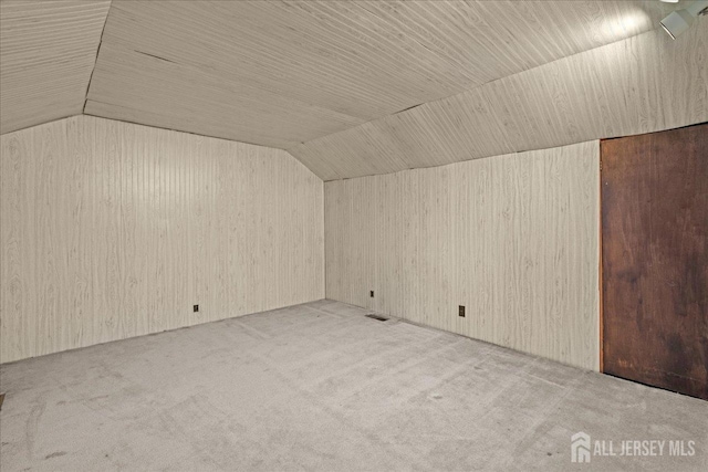 bonus room with light colored carpet and vaulted ceiling