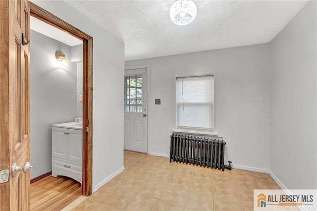 224 2nd St, South Amboy, NJ 08879 - foyer entrance featuring radiator heating unit, baseboards, parquet floors, and a textured ceiling
