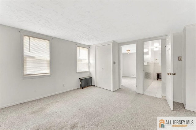224 2nd St, South Amboy, NJ 08879 - unfurnished bedroom featuring a textured ceiling, radiator, baseboards, and carpet floors