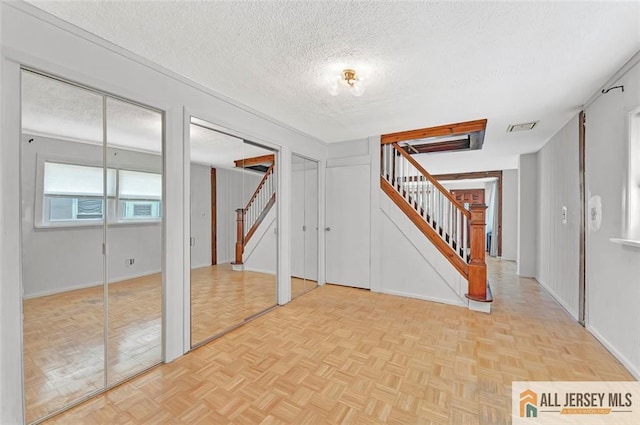 224 2nd St, South Amboy, NJ 08879 - foyer entrance with stairs, a textured ceiling, baseboards, and parquet floors
