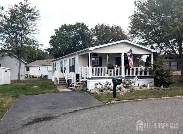 manufactured / mobile home featuring a porch and a front yard