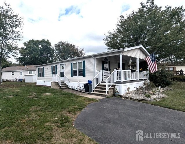 manufactured / mobile home featuring a front yard and covered porch