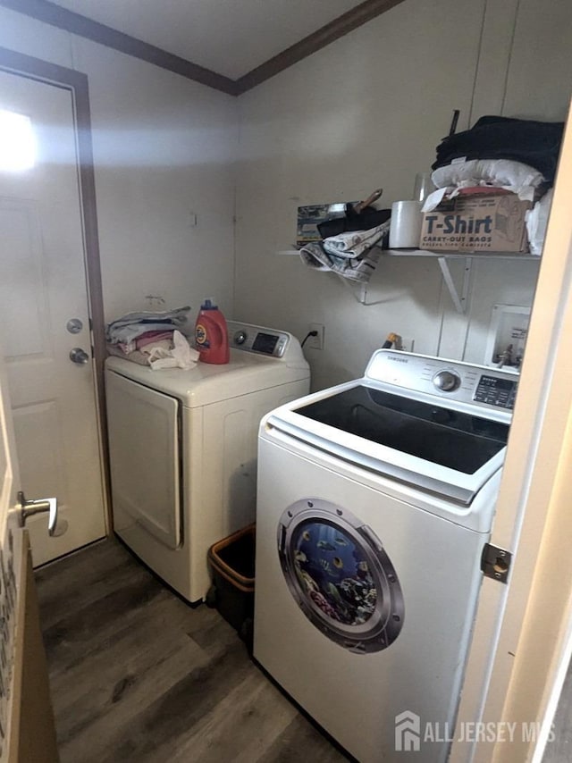 laundry area with laundry area, crown molding, washer and clothes dryer, and wood finished floors