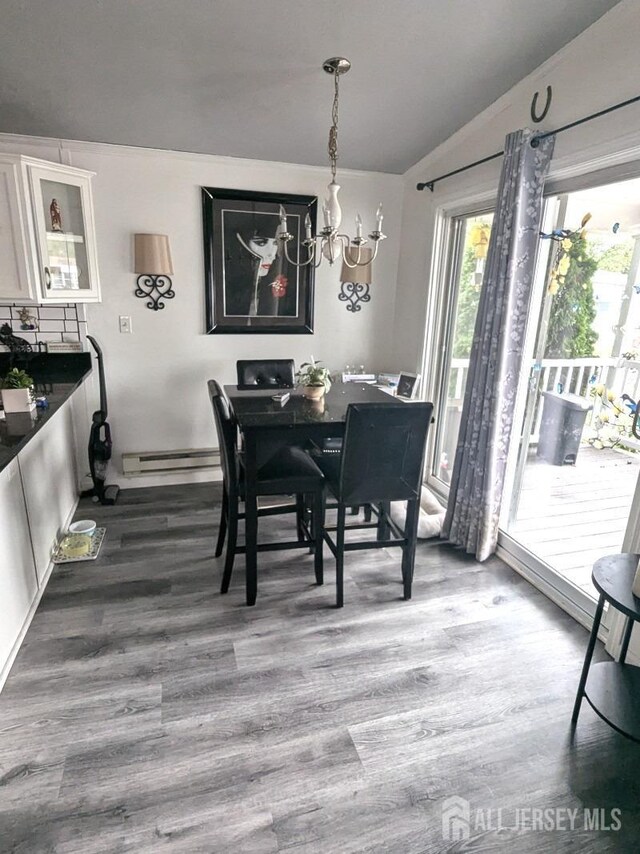 dining room featuring dark wood-style floors, lofted ceiling, a chandelier, and a baseboard radiator