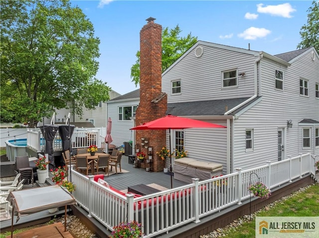 43 S Brook Dr, Milltown, NJ 08850 - back of property featuring a deck, outdoor dining area, and roof with shingles