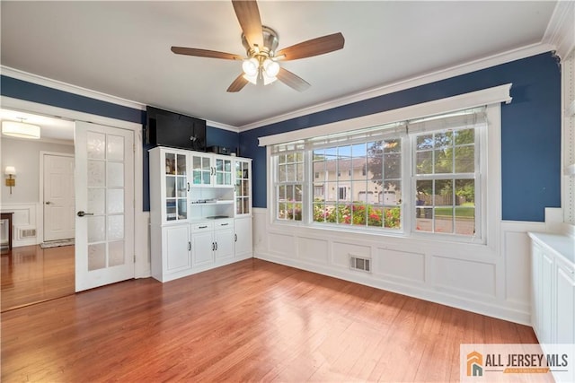 43 S Brook Dr, Milltown, NJ 08850 - spare room featuring wainscoting, ornamental molding, a decorative wall, ceiling fan, and light wood-style floors