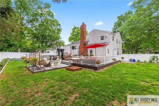 43 S Brook Dr, Milltown, NJ 08850 - back of house featuring a fenced backyard, a wooden deck, a chimney, and an outdoor living space
