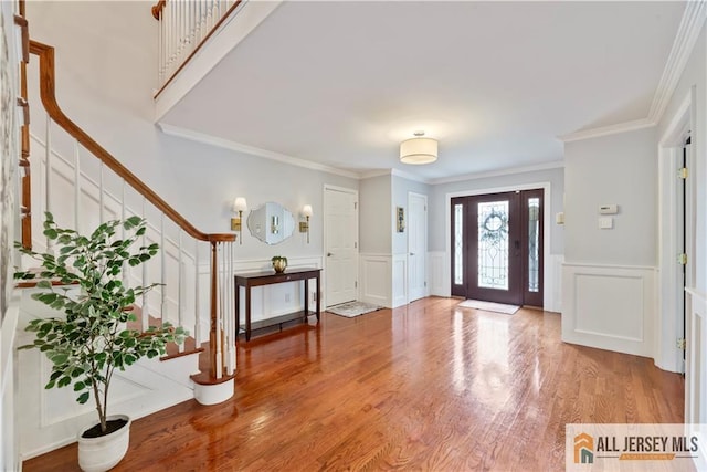 43 S Brook Dr, Milltown, NJ 08850 - foyer entrance with stairs, a decorative wall, ornamental molding, wood finished floors, and a wainscoted wall