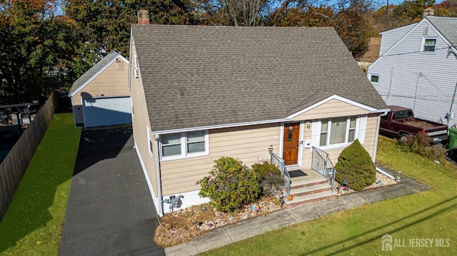 view of front of home featuring a garage, an outdoor structure, and a front yard