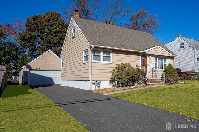 view of front facade featuring an outbuilding, a garage, and a front lawn