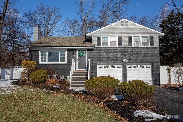 split level home with a garage and a front yard