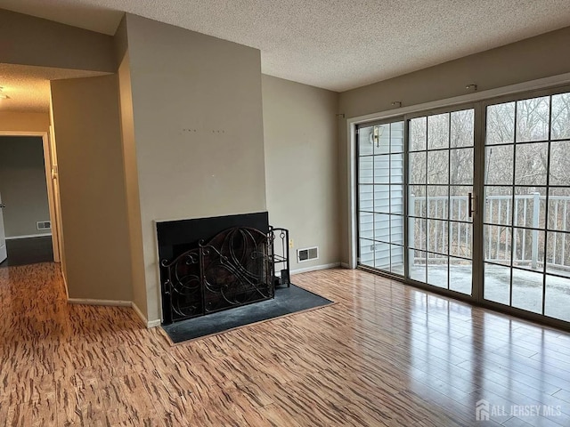 living room featuring wood-type flooring and a textured ceiling