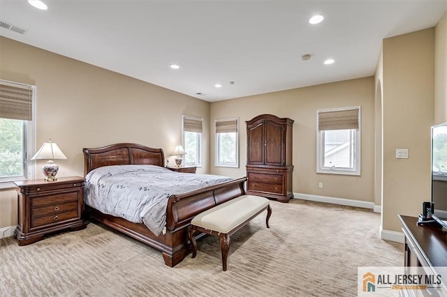 bedroom featuring multiple windows and light carpet