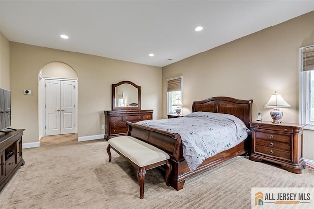 bedroom featuring light colored carpet and a closet