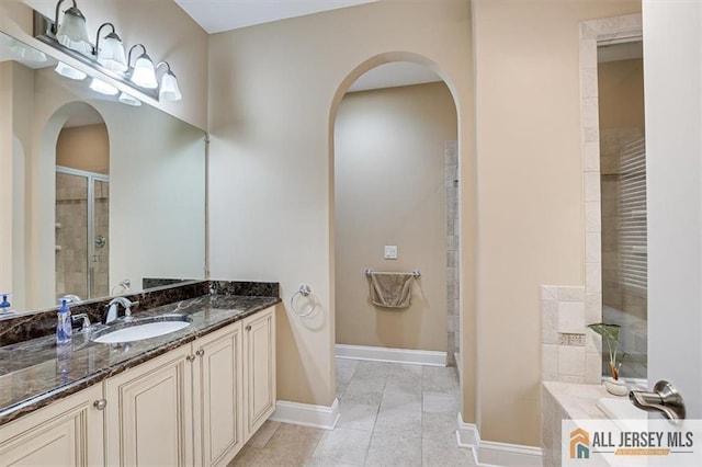 bathroom featuring tile patterned flooring, vanity, and walk in shower