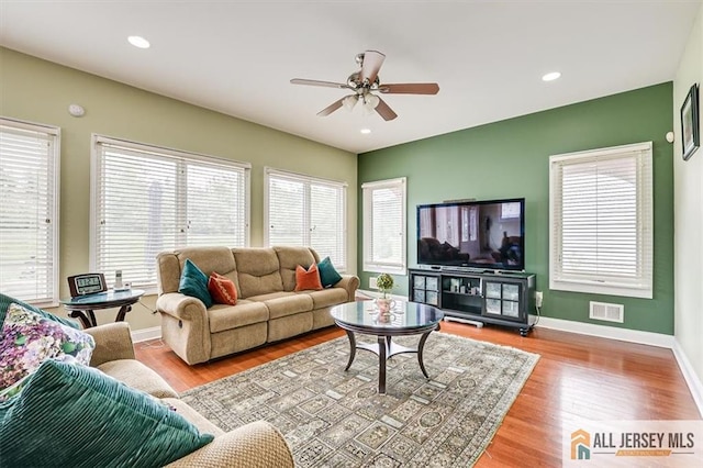 living room featuring ceiling fan and light hardwood / wood-style flooring