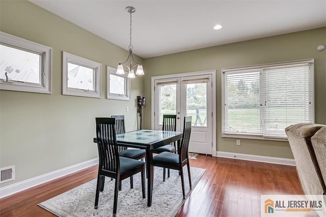 dining space featuring an inviting chandelier, hardwood / wood-style floors, and french doors