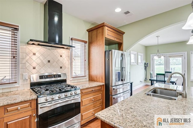 kitchen featuring stainless steel appliances, light stone countertops, ventilation hood, and sink