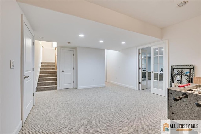 basement with french doors and light colored carpet