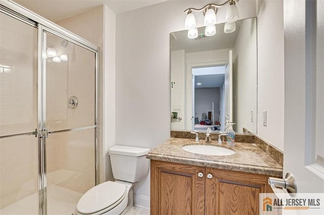 bathroom with vanity, a shower with door, and toilet