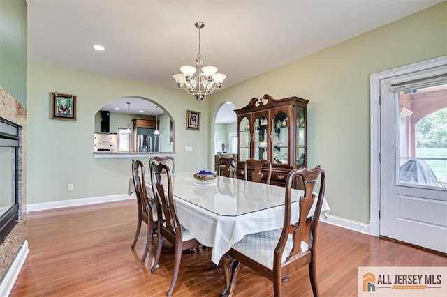 dining space with hardwood / wood-style flooring and a chandelier