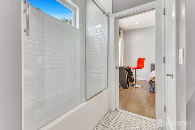 bathroom with enclosed tub / shower combo and hardwood / wood-style flooring