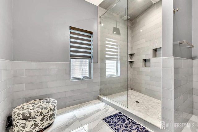 bathroom featuring tile walls and tiled shower