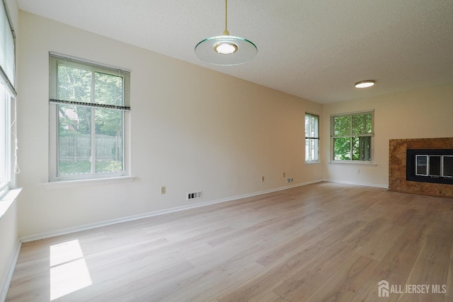 14 Carriage Pl, Edison, NJ 08820 - unfurnished living room featuring light wood finished floors, a textured ceiling, and a fireplace