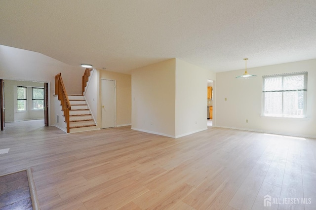 14 Carriage Pl, Edison, NJ 08820 - unfurnished living room with light wood-style flooring, stairway, and a textured ceiling