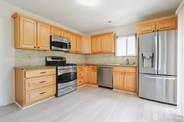 14 Carriage Pl, Edison, NJ 08820 - kitchen with stainless steel appliances, light wood-style flooring, light stone countertops, decorative backsplash, and a textured ceiling