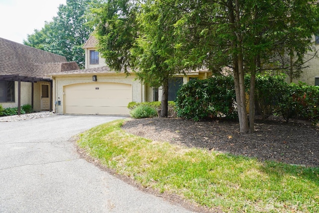 14 Carriage Pl, Edison, NJ 08820 - view of property hidden behind natural elements featuring asphalt driveway, stucco siding, and an attached garage