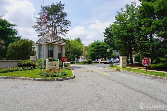 14 Carriage Pl, Edison, NJ 08820 - view of asphalt street featuring traffic signs, curbs, and a gated entry