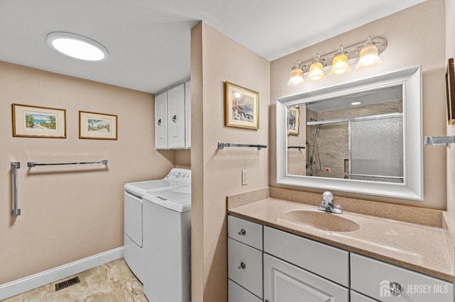 full bathroom featuring baseboards, visible vents, a shower with door, washing machine and clothes dryer, and vanity