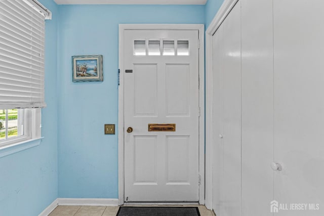 interior space with light tile patterned floors and baseboards